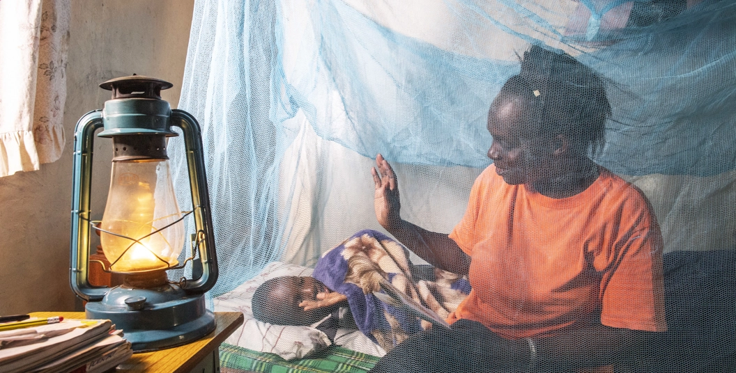 Mother and child using mosquito net in Kenya
